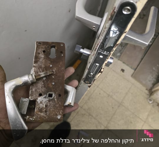 מנעול דלת ישן וחלוד ביד של מנעולן